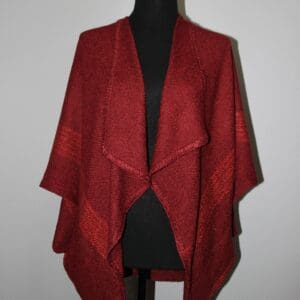 Red knitted shawl on a mannequin.