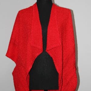 Red knitted shawl on a mannequin.