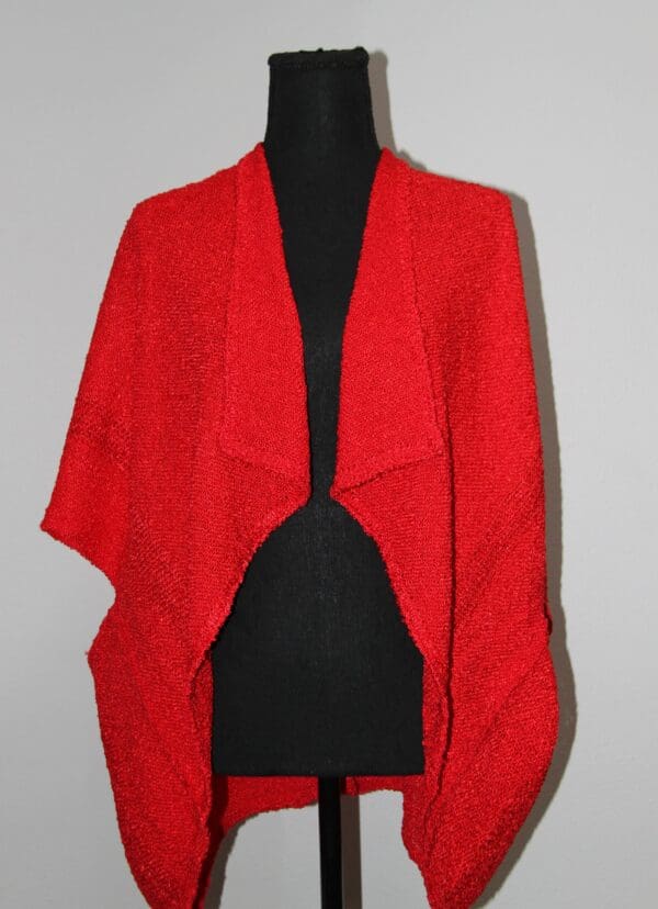 Red knitted shawl on a mannequin.